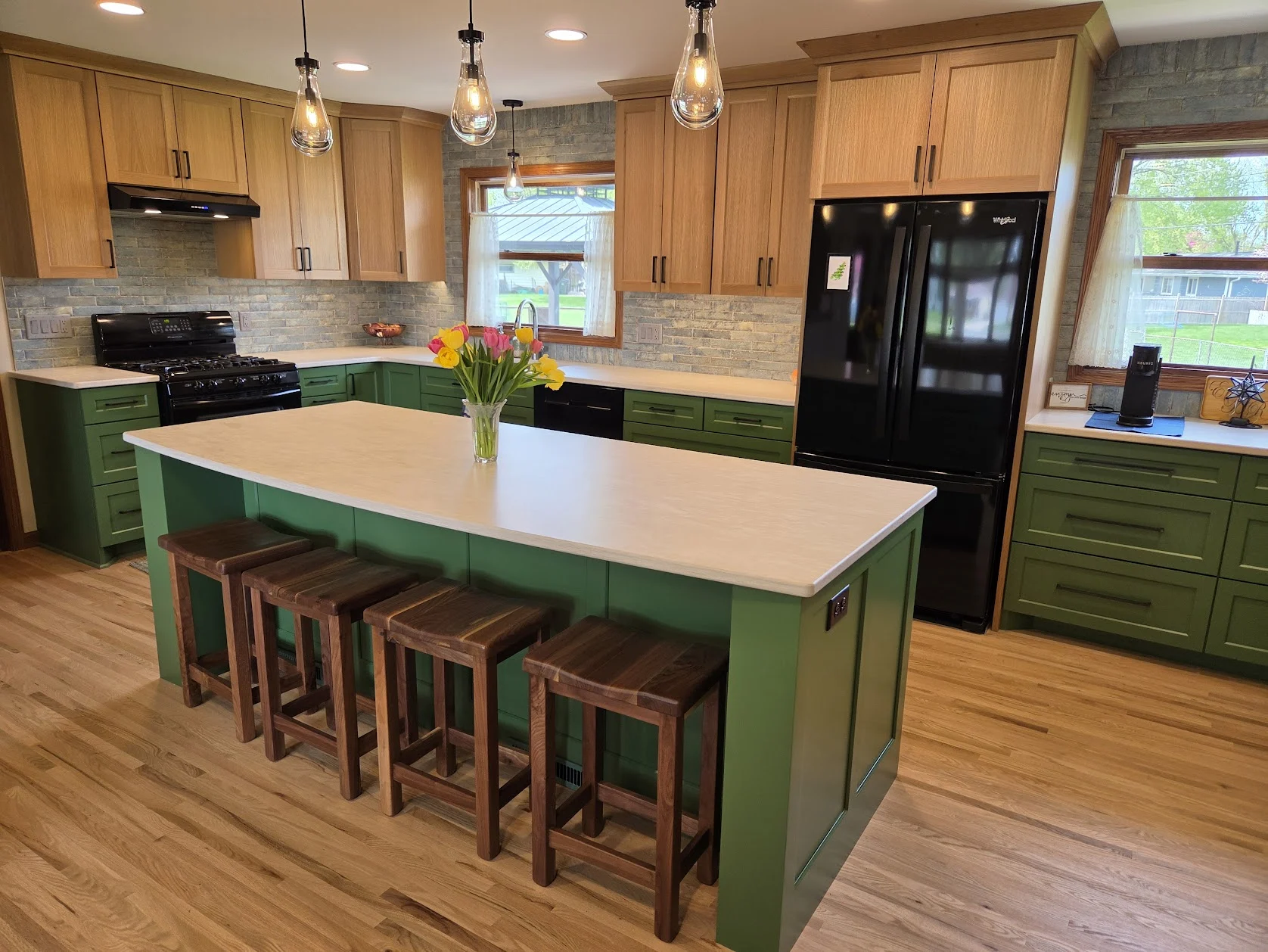 Sage cabinetry and natural wood in an Allrounder kitchen