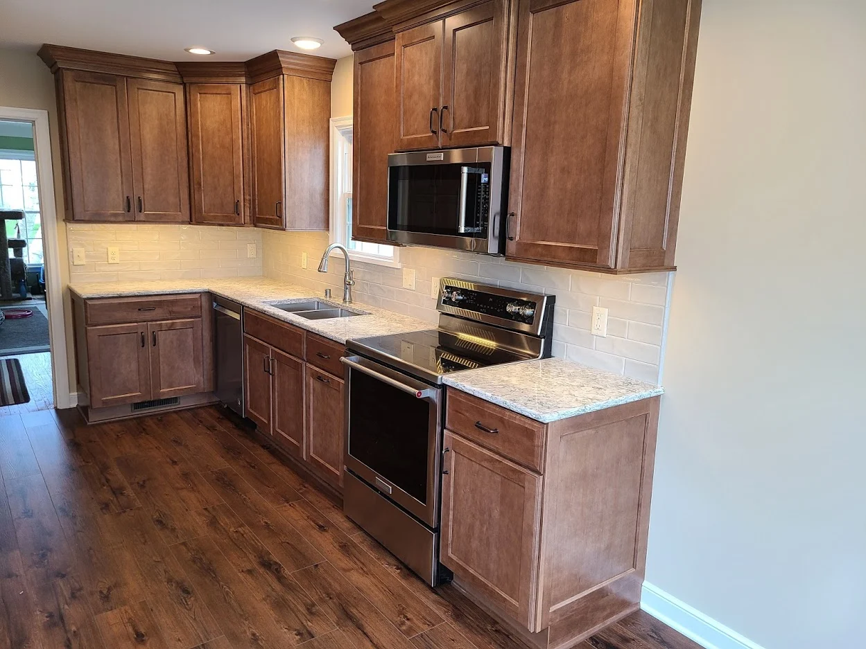 Maple cabinets, quartz counters, and stainless appliances in a completed kitchen