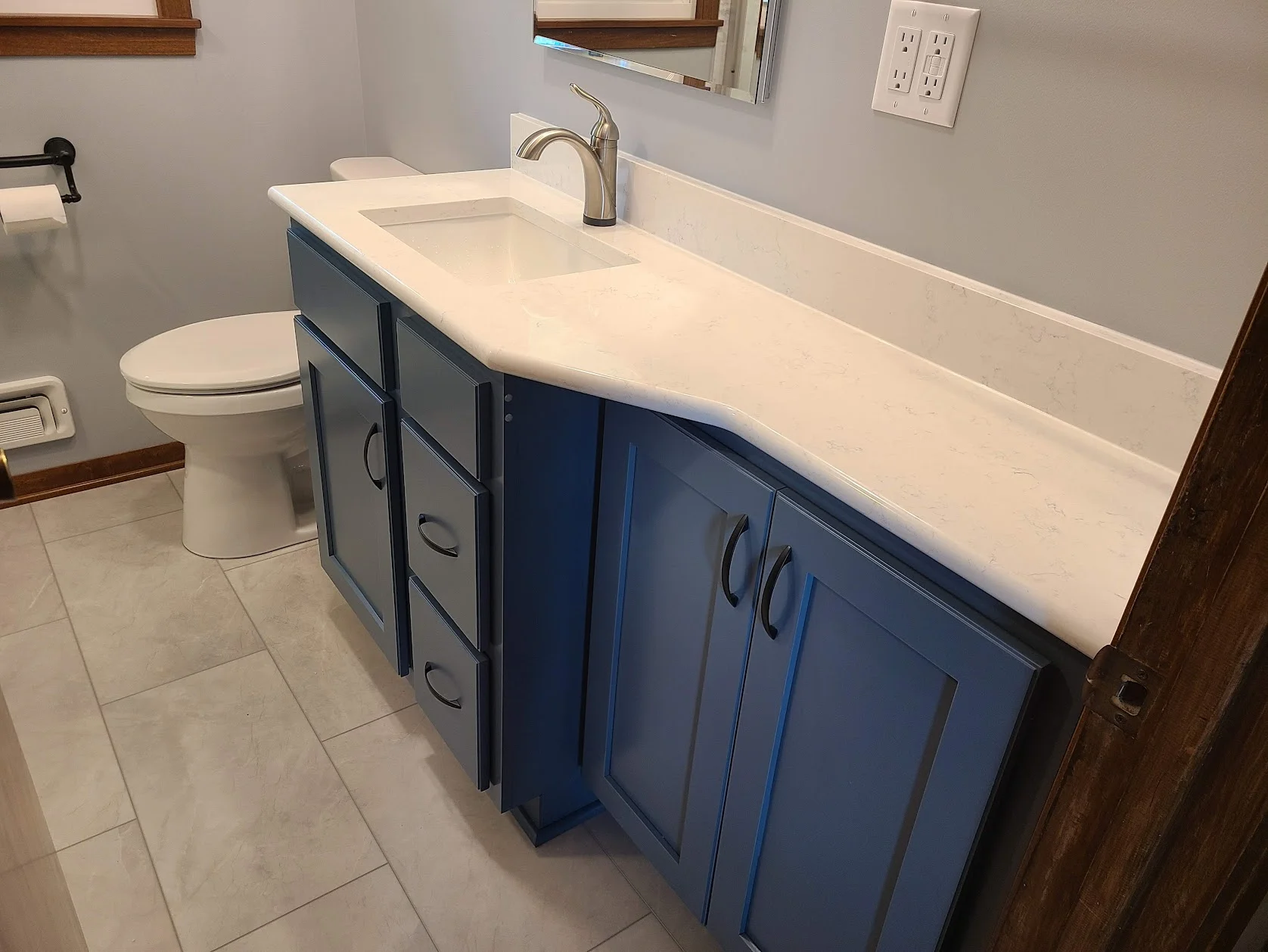 Compact remodeled bathroom with a tiled shower and floating vanity.